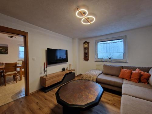 a living room with a couch and a table at Ferienwohnung Strohbergblick in Schichtshöhn
