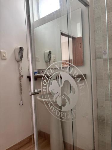 a glass door with a sign on it in a bathroom at Hotel Nutibara in Medellín
