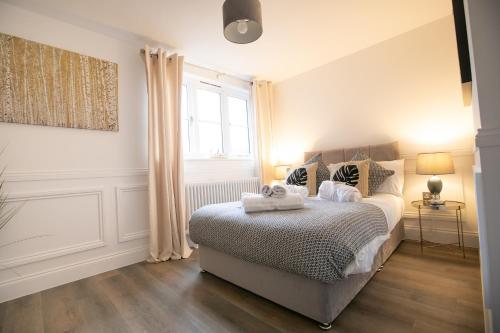 a bedroom with a bed with two towels on it at The Burlington Collection in Sheringham