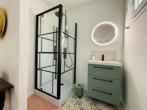 une salle de bain avec un miroir et un lavabo dans l'établissement Maison à 10 min d'Angers, à Mûrs-Érigné