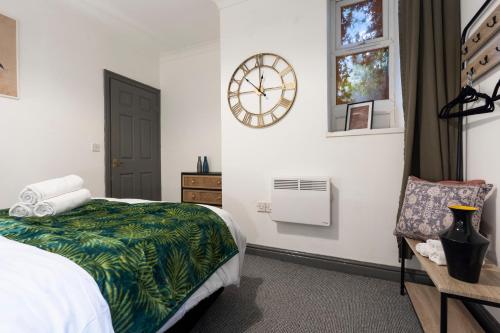 a bedroom with a bed and a clock on the wall at Mariah Flat - 2 Bedroom getaway in Pontypool in Pontypool