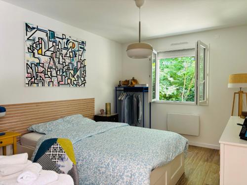 une chambre avec un lit et un tableau au mur dans l'établissement Maison à 10 min d'Angers, à Mûrs-Érigné