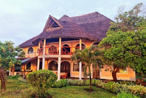 a large yellow house with a gambrel roof at Wagawimbi Villa 560 m2, Breathtaking View of the Indian Ocean, Kenya in Shimoni