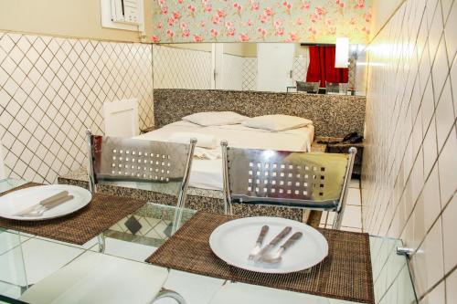 a room with two chairs and a bed with a mirror at Hotel & Motel Henrique Dias (Adults Only) in Recife
