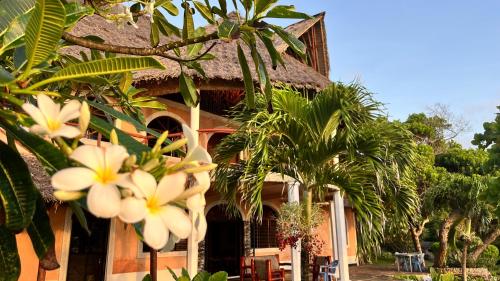 a house with palm trees in front of it at Wagawimbi Villa 560 m2, Breathtaking View of the Indian Ocean, Kenya in Shimoni