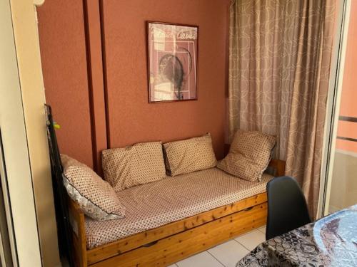 a couch with pillows on it in a bedroom at Sète location joli appartement Corniche 4 pers in Sète