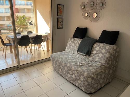 a living room with a bed and a table with chairs at Sète location joli appartement Corniche 4 pers in Sète