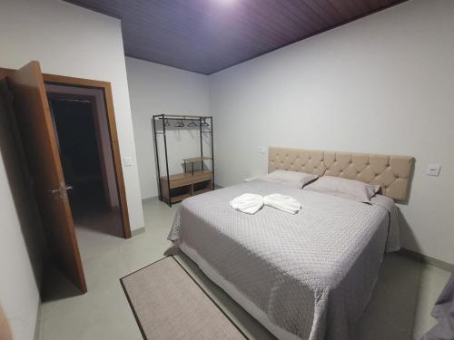 a bedroom with a bed with two white towels on it at Casa Ampla Jd Primaveras in Sinop