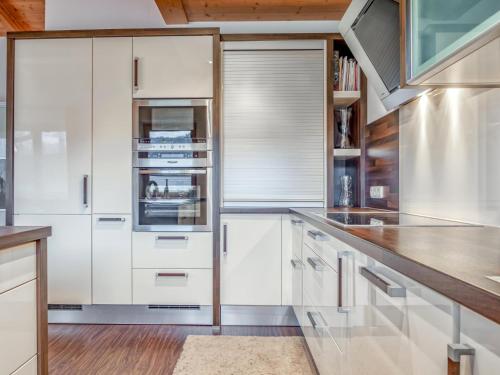 a kitchen with white cabinets and wooden ceilings at Berg und Blüte II in Sankt Jakob in Haus