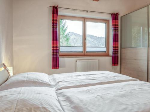 a white bed in a bedroom with a window at Berg und Blüte II in Sankt Jakob in Haus