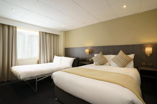 a hotel room with two beds and a window at Park hall Hotel & Spa Lancashire, a member of Radisson Individuals in Eccleston