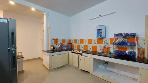 a kitchen with a sink and a refrigerator at The Hostel Stories, Varkala - Helipad Road in Varkala