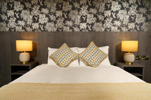 a bedroom with a bed with two lamps on it at Park hall Hotel & Spa Lancashire, a member of Radisson Individuals in Eccleston