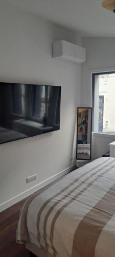 une chambre blanche avec un grand lit et une fenêtre dans l'établissement Loft Wagram - 24h - 10min circuit en tram, au Mans