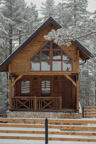 a wooden cabin with a large window and stairs at Pino House Zlatibor-Tornik in Ribnica