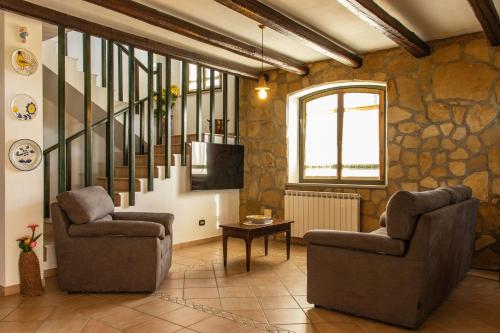 a living room with two chairs and a television at Villa Carlotta in Nuxis