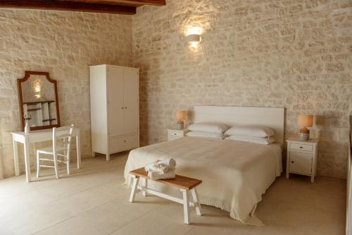 a bedroom with a bed and a table and a mirror at Masseria Surace in Noci