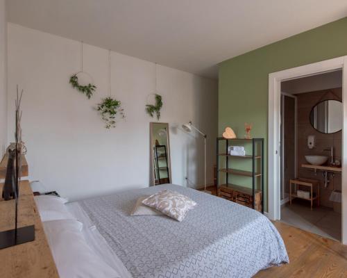 a bedroom with a white bed and a bathroom at BACARìA DA DANTE Rooms in Bassano del Grappa