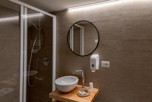 a bathroom with a sink and a mirror at BACARìA DA DANTE Rooms in Bassano del Grappa