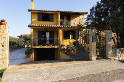 a yellow house with a gate in front of it at Villa Carlotta in Nuxis