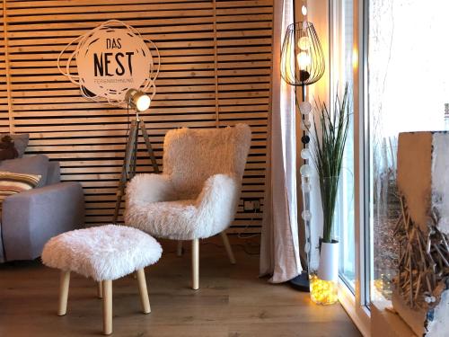 a living room with two chairs and a sign that reads its nest at Das Nest Winterberg in Winterberg