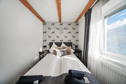 a bedroom with a white bed with a window at Innsbruck City Chalet in Innsbruck