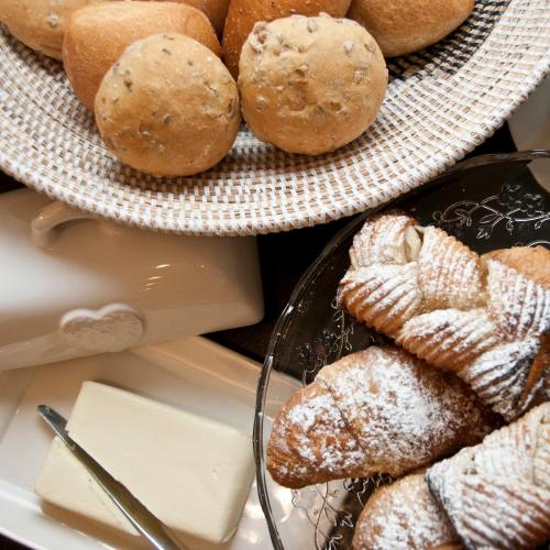 a bunch of pastries on a plate and a plate of bread at Hotel Garnì Villa Maria in Riva del Garda