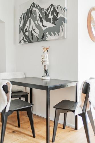 a black table with two chairs and a vase on top at Innsbruck City Chalet in Innsbruck