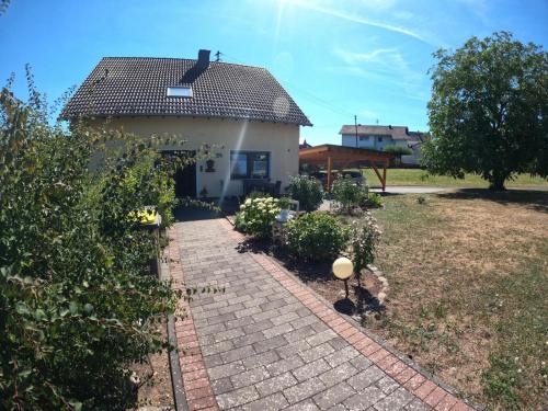 a small house with a brick walkway in a yard at Ferienwohnung Tine in Oberhausen