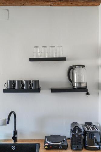 a kitchen counter with glasses on shelves on the wall at Innsbruck City Chalet in Innsbruck