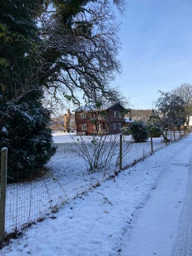 a fence covered in snow in front of a house at Jul i Skovhuset in Ringsted