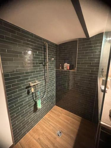 a bathroom with a shower with a black brick wall at Zimmer Mühlenbach, ein Zimmer in FeWo mit 2 Zi in Schieder-Schwalenberg