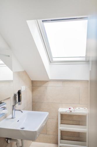 a bathroom with a sink and a skylight at Innsbruck City Chalet in Innsbruck