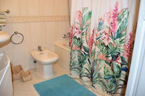a bathroom with a toilet and a shower curtain at Apartamento Médano Playa in El Médano