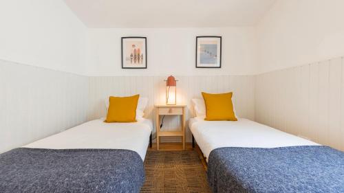 two beds sitting next to each other in a room at Pátio Vilareto - Villa Fernanda in São Domingos de Rana