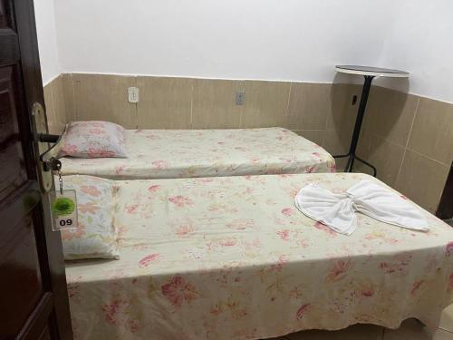 a bedroom with two beds with a bow on them at Pousada Manhã Serena in Rio das Ostras