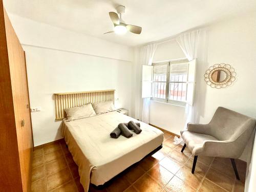 a bedroom with a bed and a chair at Vivienda céntrica cerca de todo in Alicante