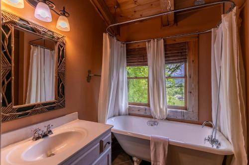 a bathroom with a tub and a sink and a window at St Johns Ridge in Sugar Grove