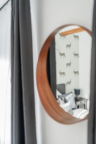 a mirror reflecting a bedroom with a deer wall at Innsbruck City Chalet in Innsbruck