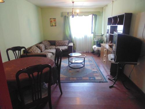sala de estar con sofá y mesa en Hostal Arrayan en Valdivia