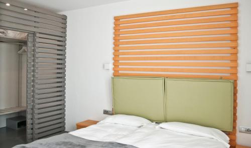 a bedroom with a bed with a wooden headboard at Hotel Garnì Villa Maria in Riva del Garda