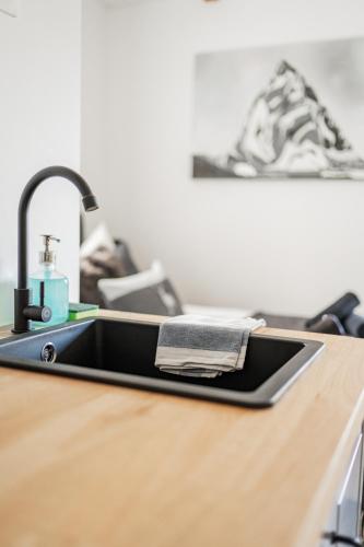 a kitchen sink on a wooden counter with a sink at Innsbruck City Chalet in Innsbruck
