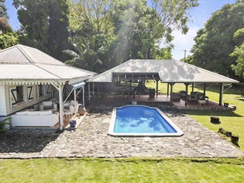a house with a swimming pool and a gazebo at Villa du Morne dOrange in Saint-Pierre