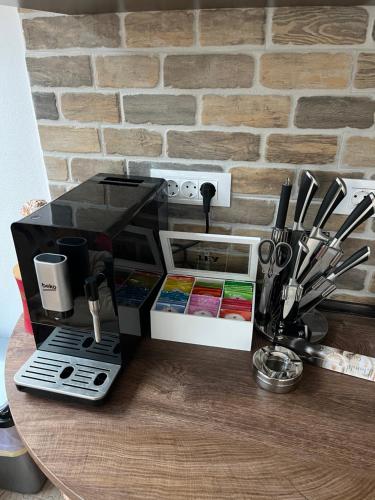 a coffee maker on a table next to a brick wall at Casa Ana in Câmpulung Moldovenesc