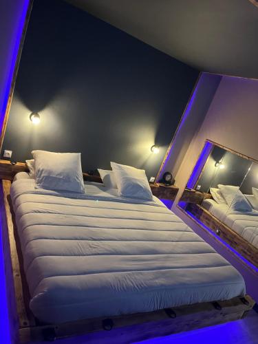 ArcにあるMieux qua lhotelの紫色の照明が備わる客室内の大型ベッド2台
