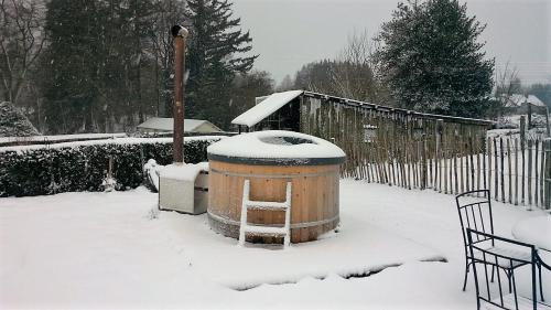 a snow covered yard with a trash can and a fence at The BlackSmith's House in Libin