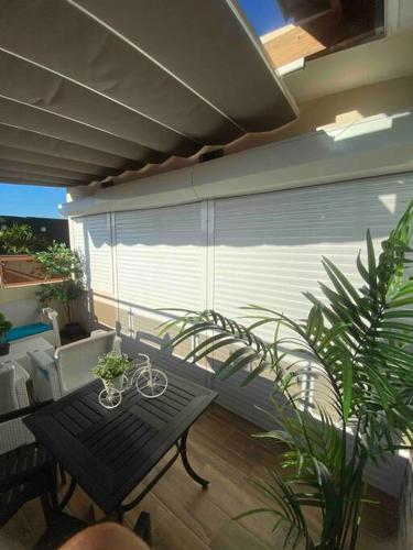 a patio with a bench and a table and plants at Acogedora partamento cerca de la embajada in Santo Domingo