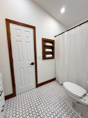 a white bathroom with a toilet and a shower at Riverfront Retreat in Columbus in Columbus