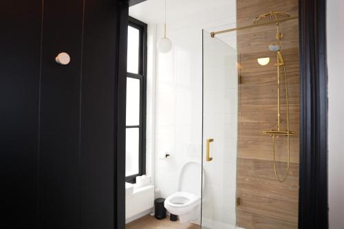 a bathroom with a toilet and a glass shower at Boutique Hotel Johannes in Delft