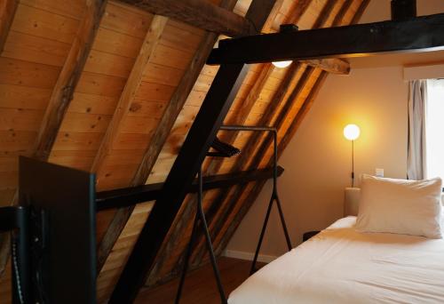 a loft bed in a room with wooden ceilings at Boutique Hotel Johannes in Delft